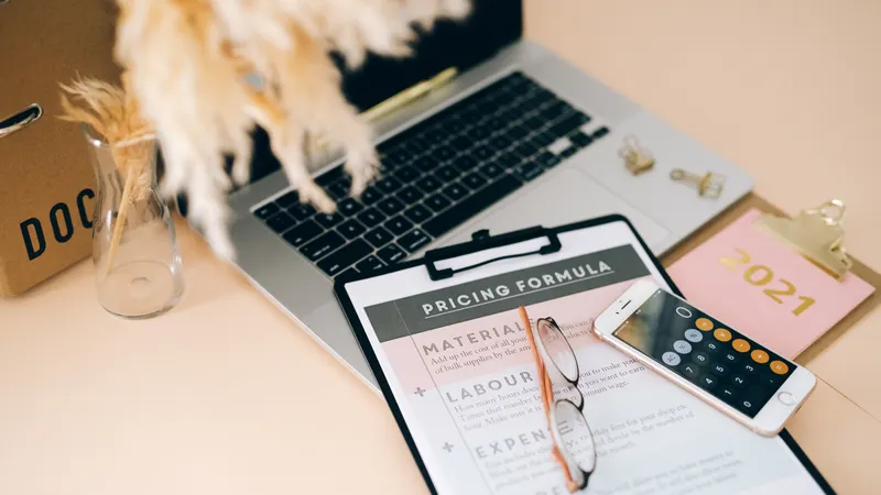 Pricing document and calculator on a desk for a website design proposal