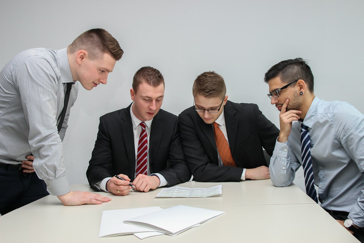 Four men reviewing paperwork at a table