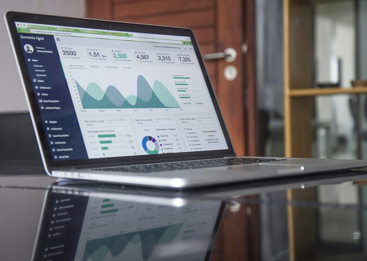 Laptop on a glass-top table with statistics