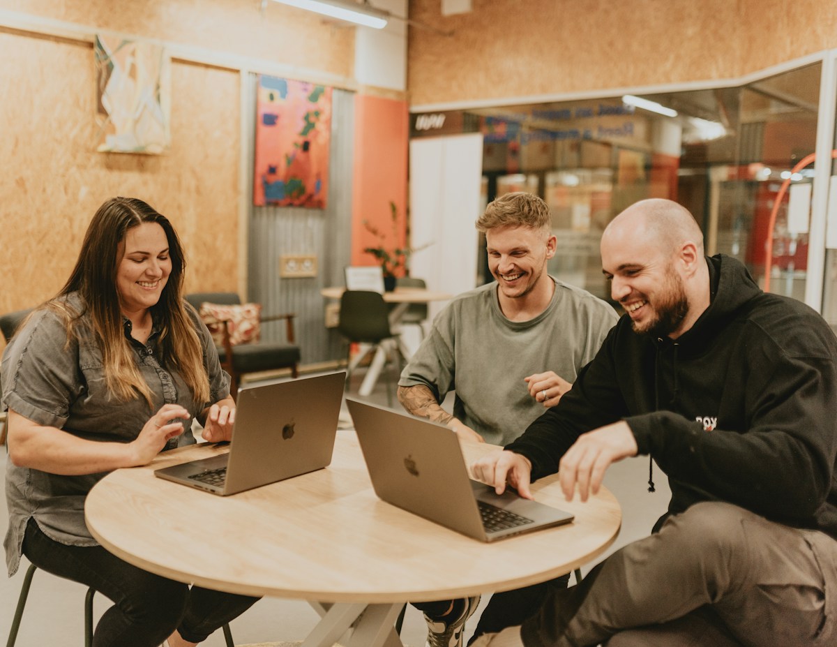 Three people working and laughing together
