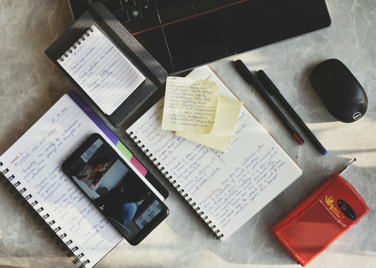 Desk with a laptop, notepad, pen and phone